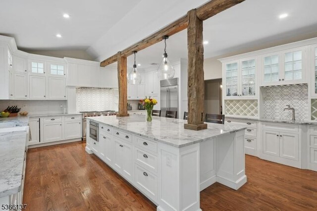 4 Knollwood Ln, Hardyston Twp, NJ 07460 - kitchen with built in appliances, white cabinetry, a center island, vaulted ceiling, and backsplash