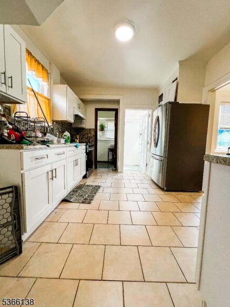 453 Beardsley Ave, Bloomfield Twp, NJ 07003 - kitchen with freestanding refrigerator, white cabinets, plenty of natural light, and decorative backsplash