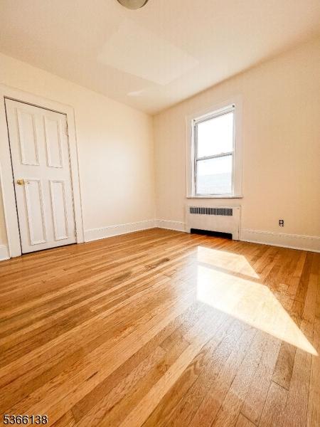 453 Beardsley Ave, Bloomfield Twp, NJ 07003 - spare room with radiator and light wood finished floors