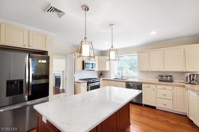 52 E Ave, Washington Twp, NJ 07840 - kitchen featuring appliances with stainless steel finishes, decorative backsplash, crown molding, a kitchen island, and hanging light fixtures