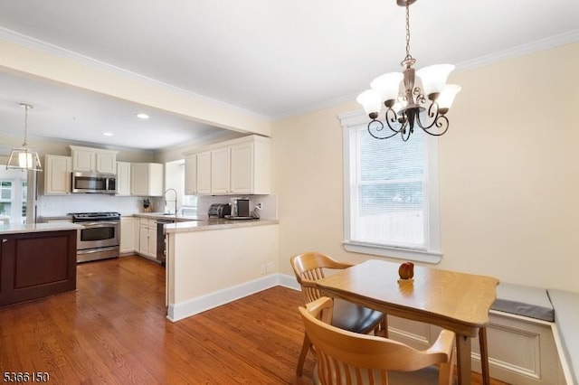 52 E Ave, Washington Twp, NJ 07840 - kitchen featuring stainless steel appliances, a chandelier, light countertops, dark wood-style floors, and decorative light fixtures