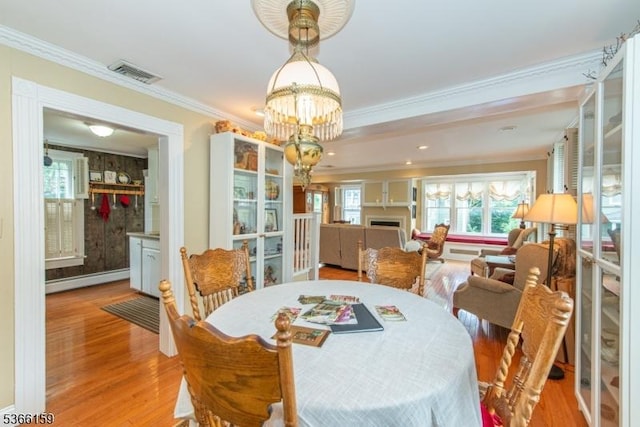 6 Mc Clintock Pl, Parsippany-Troy Hills Twp, NJ 07878 - dining area with a baseboard radiator, a chandelier, ornamental molding, light wood-style floors, and a fireplace