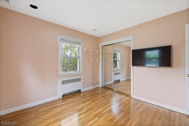 3 Casey Ave, East Hanover Twp, NJ 07936 - empty room featuring radiator heating unit, light wood-type flooring, and healthy amount of natural light