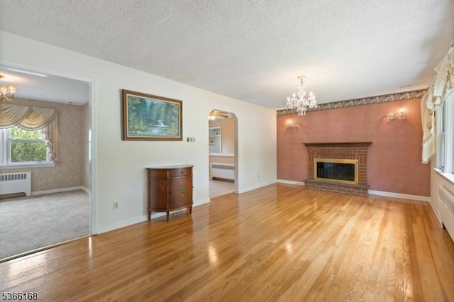 3 Casey Ave, East Hanover Twp, NJ 07936 - unfurnished living room with radiator heating unit, a chandelier, arched walkways, and a textured ceiling