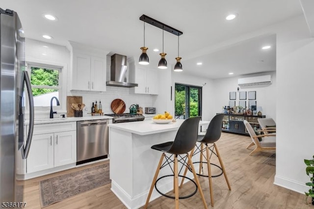 24 Roxbury Dr, Roxbury Twp, NJ 07847 - kitchen with stainless steel appliances, wall chimney exhaust hood, a wall mounted air conditioner, light countertops, and a kitchen bar