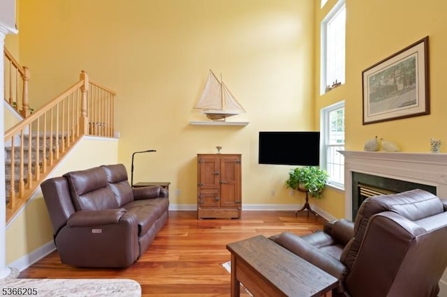 1305 S Branch Dr, Readington Twp, NJ 08889 - living area featuring a towering ceiling, stairs, light wood finished floors, and a fireplace