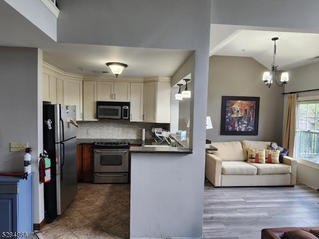 1-23 Pine Cres Unit 23, Vernon Twp, NJ 07462 - kitchen with appliances with stainless steel finishes, backsplash, open floor plan, a chandelier, and lofted ceiling