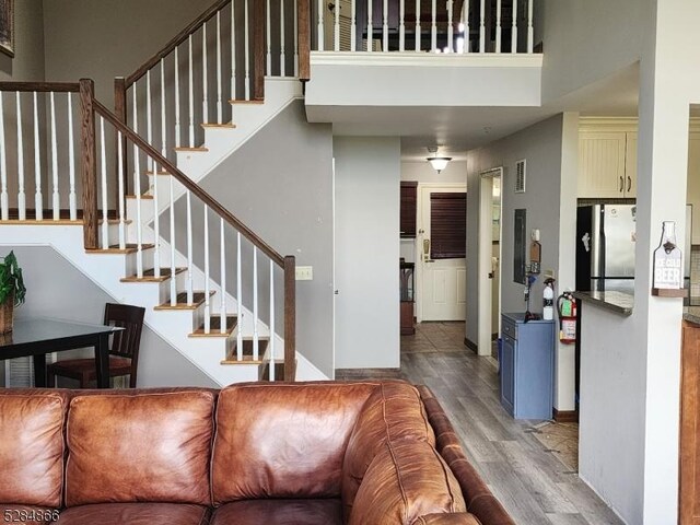 1-23 Pine Cres Unit 23, Vernon Twp, NJ 07462 - living area with wood finished floors, a towering ceiling, and stairway