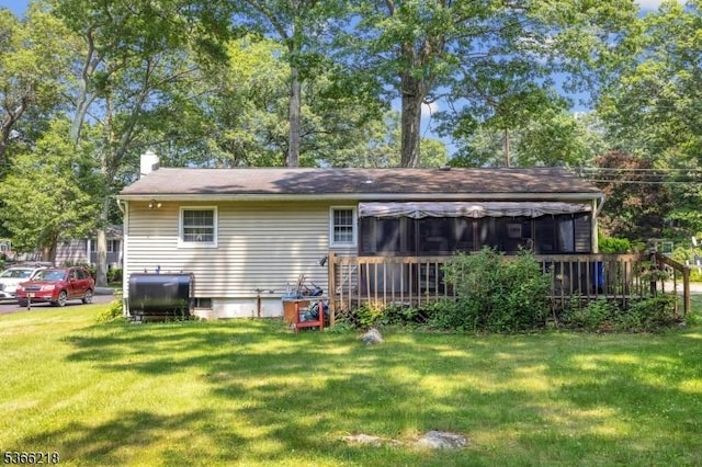 15 Stony Brook Rd, Byram Twp, NJ 07874 - rear view of property featuring a yard, a sunroom, a chimney, oil tank, and a deck