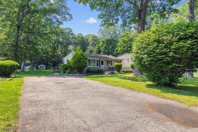 15 Stony Brook Rd, Byram Twp, NJ 07874 - view of front of house featuring a storage shed, a front lawn, and asphalt driveway