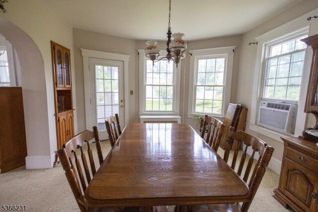 48 Keller Ave, Rockaway Boro, NJ 07866 - dining space featuring a chandelier, arched walkways, light colored carpet, and cooling unit