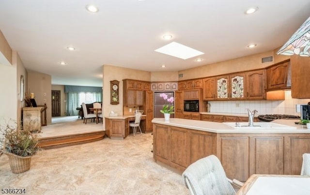 856 Colonial Arms Rd, Union Twp, NJ 07083 - kitchen featuring black microwave, brown cabinetry, a skylight, a peninsula, and light countertops