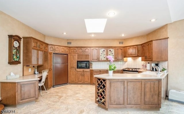 856 Colonial Arms Rd, Union Twp, NJ 07083 - kitchen featuring freestanding refrigerator, black microwave, a peninsula, a skylight, and light countertops