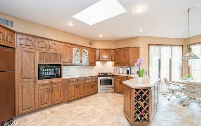 856 Colonial Arms Rd, Union Twp, NJ 07083 - kitchen featuring black microwave, stainless steel range with gas stovetop, refrigerator, brown cabinetry, and a peninsula