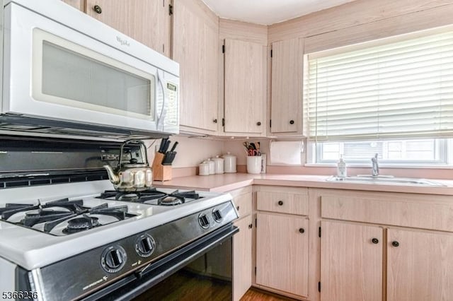21 Academy Ter, Linden City, NJ 07036 - kitchen with white microwave, range with gas stovetop, light brown cabinetry, and light countertops