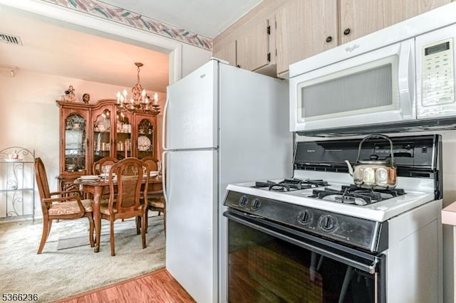 21 Academy Ter, Linden City, NJ 07036 - kitchen featuring white microwave, gas range oven, a chandelier, light wood-type flooring, and pendant lighting
