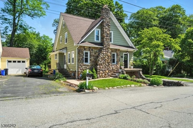 86 Riverside Dr, Denville Twp, NJ 07834 - view of front of home featuring driveway, an outbuilding, stone siding, and a chimney
