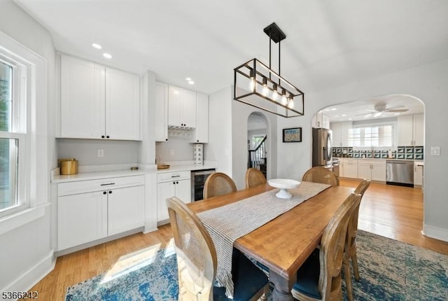 86 Riverside Dr, Denville Twp, NJ 07834 - dining space featuring arched walkways, beverage cooler, light wood-style flooring, bar area, and recessed lighting
