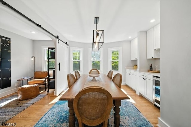 86 Riverside Dr, Denville Twp, NJ 07834 - dining space with a barn door, light wood-style flooring, beverage cooler, recessed lighting, and a bar