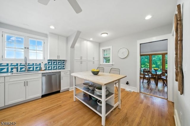 86 Riverside Dr, Denville Twp, NJ 07834 - kitchen featuring dishwasher, light countertops, white cabinetry, decorative backsplash, and light wood-type flooring