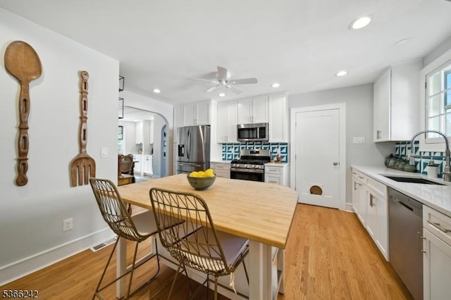 86 Riverside Dr, Denville Twp, NJ 07834 - kitchen featuring stainless steel appliances, a ceiling fan, light countertops, white cabinets, and light wood-style flooring