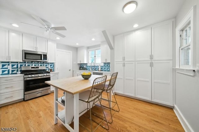 86 Riverside Dr, Denville Twp, NJ 07834 - kitchen with stainless steel appliances, white cabinetry, tasteful backsplash, ceiling fan, and light wood finished floors