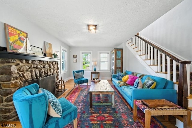 86 Riverside Dr, Denville Twp, NJ 07834 - living area with a fireplace, a textured ceiling, wood finished floors, and stairway