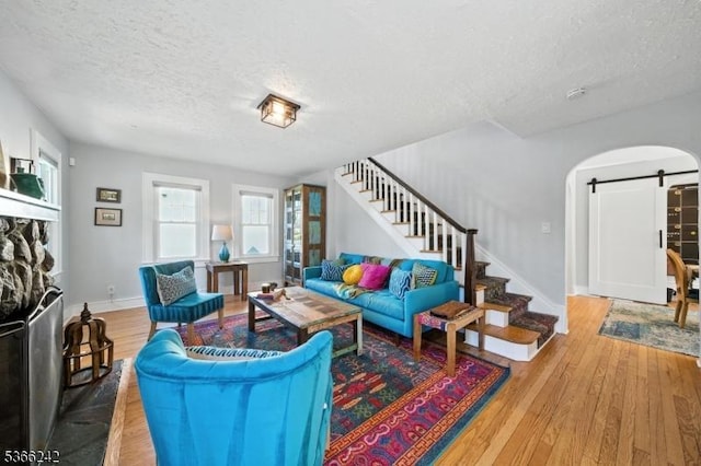 86 Riverside Dr, Denville Twp, NJ 07834 - living area featuring a barn door, a textured ceiling, stairway, and wood finished floors