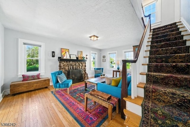 86 Riverside Dr, Denville Twp, NJ 07834 - living area featuring stairway, hardwood / wood-style flooring, a fireplace, and a textured ceiling