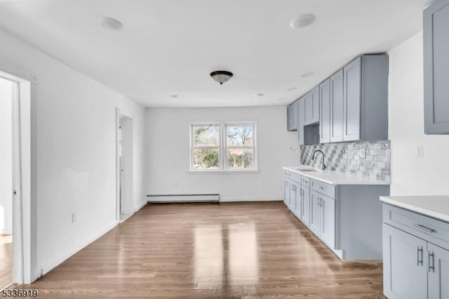 797 Passaic Ave, West Caldwell Twp, NJ 07006 - kitchen featuring baseboard heating, light countertops, decorative backsplash, and wood finished floors