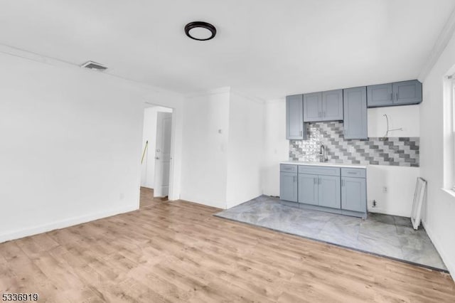 797 Passaic Ave, West Caldwell Twp, NJ 07006 - kitchen featuring backsplash, light wood finished floors, light countertops, and crown molding