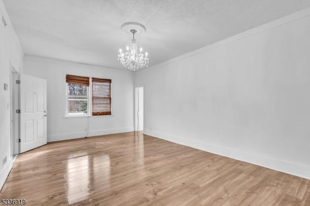 797 Passaic Ave, West Caldwell Twp, NJ 07006 - empty room with a chandelier, crown molding, wood finished floors, and a textured ceiling