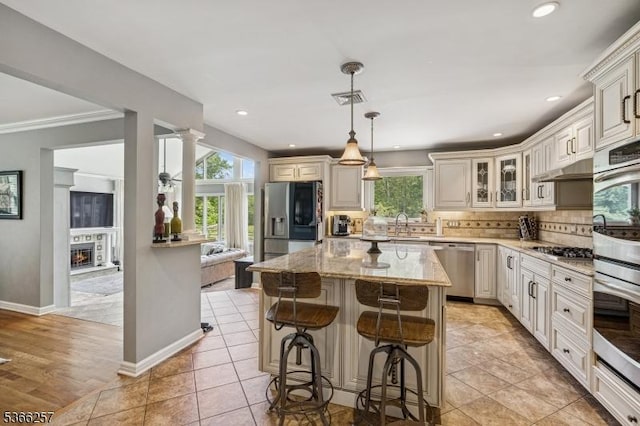 1127 Mountain Ave, Berkeley Heights Twp, NJ 07922 - kitchen featuring appliances with stainless steel finishes, healthy amount of natural light, light stone counters, glass insert cabinets, and recessed lighting