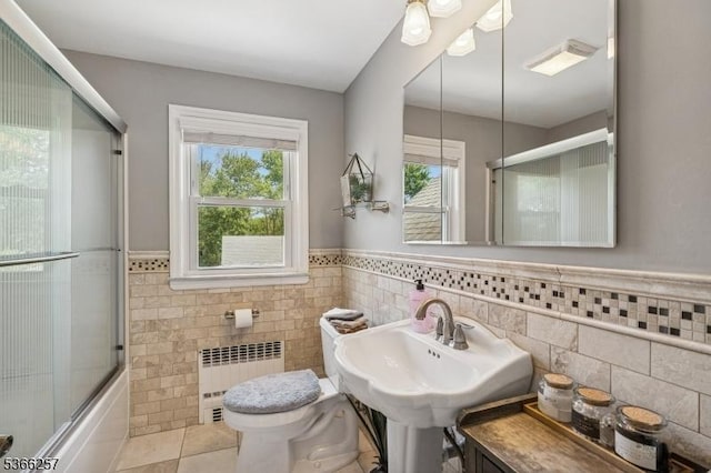 1127 Mountain Ave, Berkeley Heights Twp, NJ 07922 - bathroom featuring radiator, tile walls, a wainscoted wall, tile patterned floors, and bath / shower combo with glass door