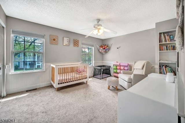 2904 Pinhorn Dr, Bridgewater Twp, NJ 08807 - bedroom with a textured ceiling, a wainscoted wall, carpet, and a ceiling fan