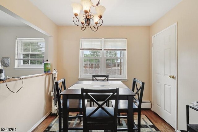 1245B Valley Rd Unit B, Wayne Twp, NJ 07470 - dining space featuring healthy amount of natural light, a chandelier, wood finished floors, and a baseboard heating unit