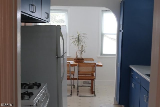 2132 Alberta Ave, Linden City, NJ 07036 - kitchen featuring white range with gas stovetop, blue cabinetry, light floors, arched walkways, and light countertops