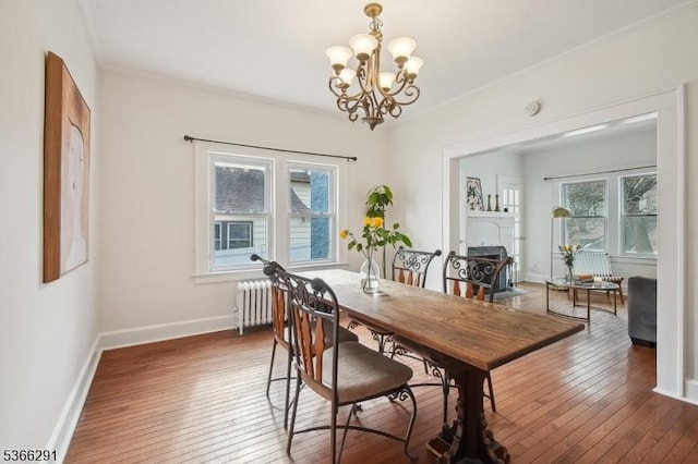 64 Rollinson St, West Orange Twp, NJ 07052 - dining space featuring healthy amount of natural light, wood-type flooring, a chandelier, radiator, and crown molding