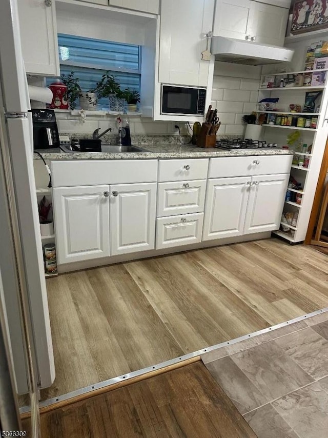 16 Sale St, Moonachie Boro, NJ 07074 - kitchen with freestanding refrigerator, white cabinets, tasteful backsplash, light wood-style flooring, and light stone counters