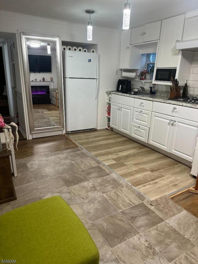 16 Sale St, Moonachie Boro, NJ 07074 - kitchen featuring freestanding refrigerator, white cabinets, ornamental molding, black microwave, and stainless steel gas cooktop