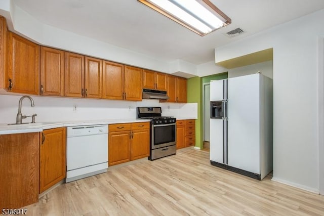 34 Copperfield Rd, Scotch Plains Twp, NJ 07076 - kitchen with white appliances, under cabinet range hood, brown cabinetry, light wood-type flooring, and light countertops