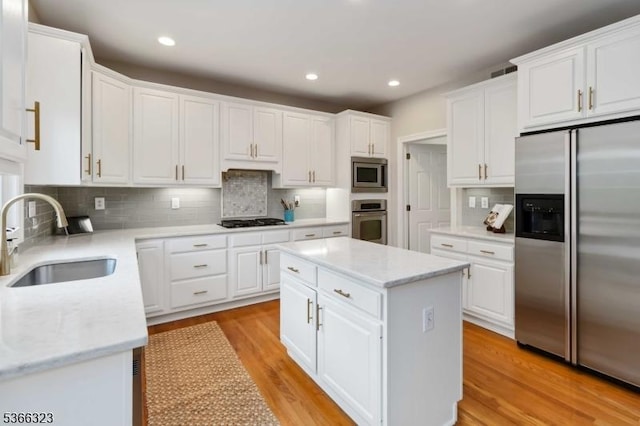 8 Forest Dr, Morris Twp, NJ 07960 - kitchen featuring stainless steel appliances, a kitchen island, decorative backsplash, white cabinetry, and light wood-style floors