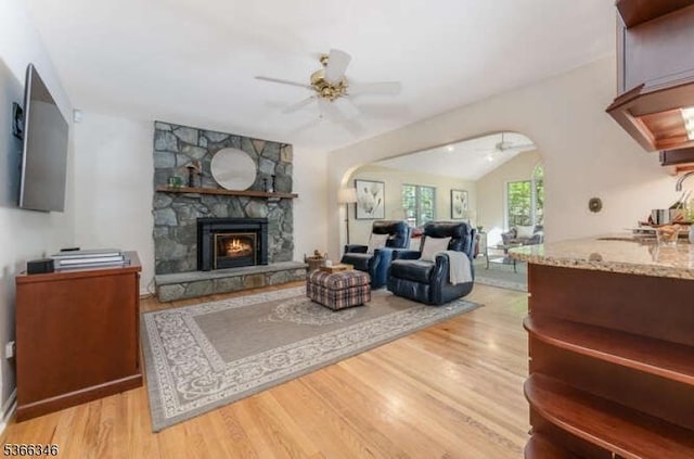 1 Craig Rd, Clinton Twp, NJ 08801 - living area featuring ceiling fan, light wood-style floors, a stone fireplace, arched walkways, and lofted ceiling