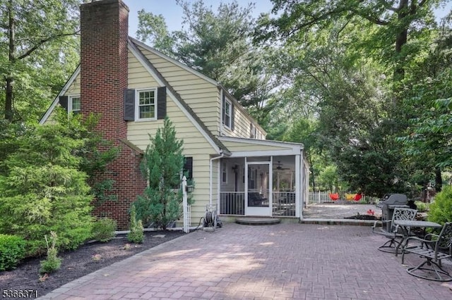 924 Maurice Ave, Rahway City, NJ 07065 - back of property featuring a chimney, a sunroom, and a patio