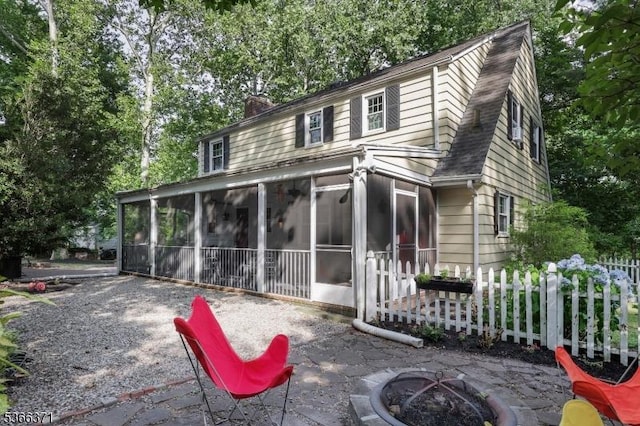 924 Maurice Ave, Rahway City, NJ 07065 - rear view of house with a sunroom, an outdoor fire pit, a chimney, and a patio