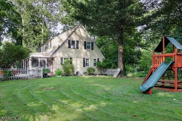 924 Maurice Ave, Rahway City, NJ 07065 - rear view of house with a playground, a sunroom, and view of wooded area