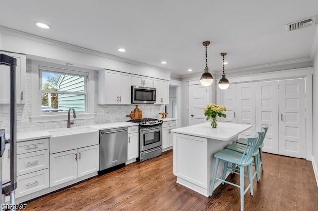 913 Columbus Ave, Westfield Town, NJ 07090 - kitchen featuring stainless steel appliances, ornamental molding, light countertops, tasteful backsplash, and white cabinets