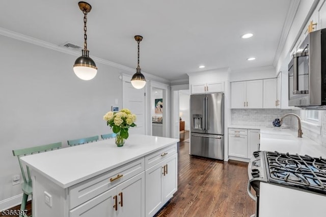 913 Columbus Ave, Westfield Town, NJ 07090 - kitchen featuring appliances with stainless steel finishes, ornamental molding, light countertops, decorative light fixtures, and white cabinetry