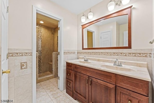 88 San Antonio Ave, Nutley Twp, NJ 07110 - full bathroom featuring tile walls, double vanity, tile patterned floors, a shower stall, and a wainscoted wall