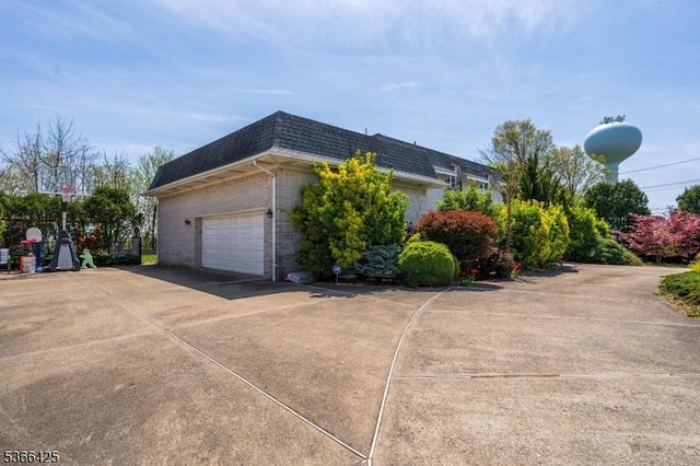 444 Harrison Ave, Lodi Boro, NJ 07644 - view of side of home featuring mansard roof, brick siding, concrete driveway, roof with shingles, and an attached garage